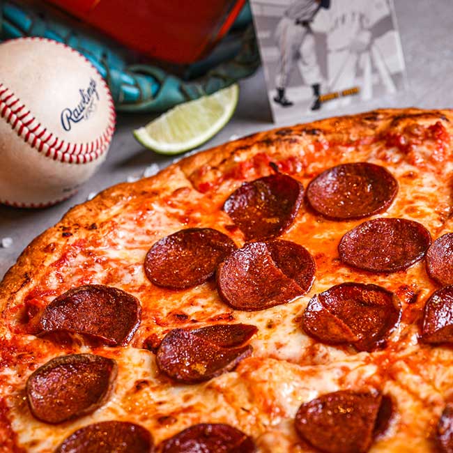 Tucson pizza with a baseball, glove, lime slice, and a photo in the background.